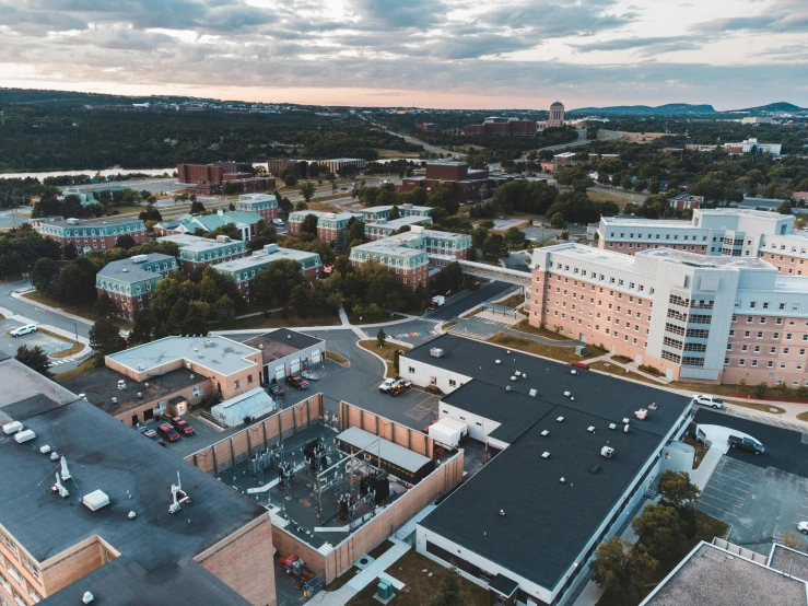 an aerial view of a city at sunset, by Jeffrey Smith, unsplash, medical complex, southdale center, exterior wide shot, at college