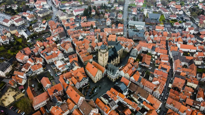 an aerial view of a city with a clock tower, by Daniel Lieske, pexels, detmold charles maurice, 🦩🪐🐞👩🏻🦳, quaint village, tiled roofs