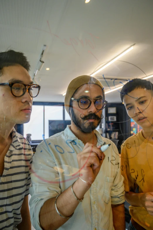 a group of three men standing next to each other, inspired by NEVERCREW, process art, in the office, thin round glasses, concentrated, lgbtq