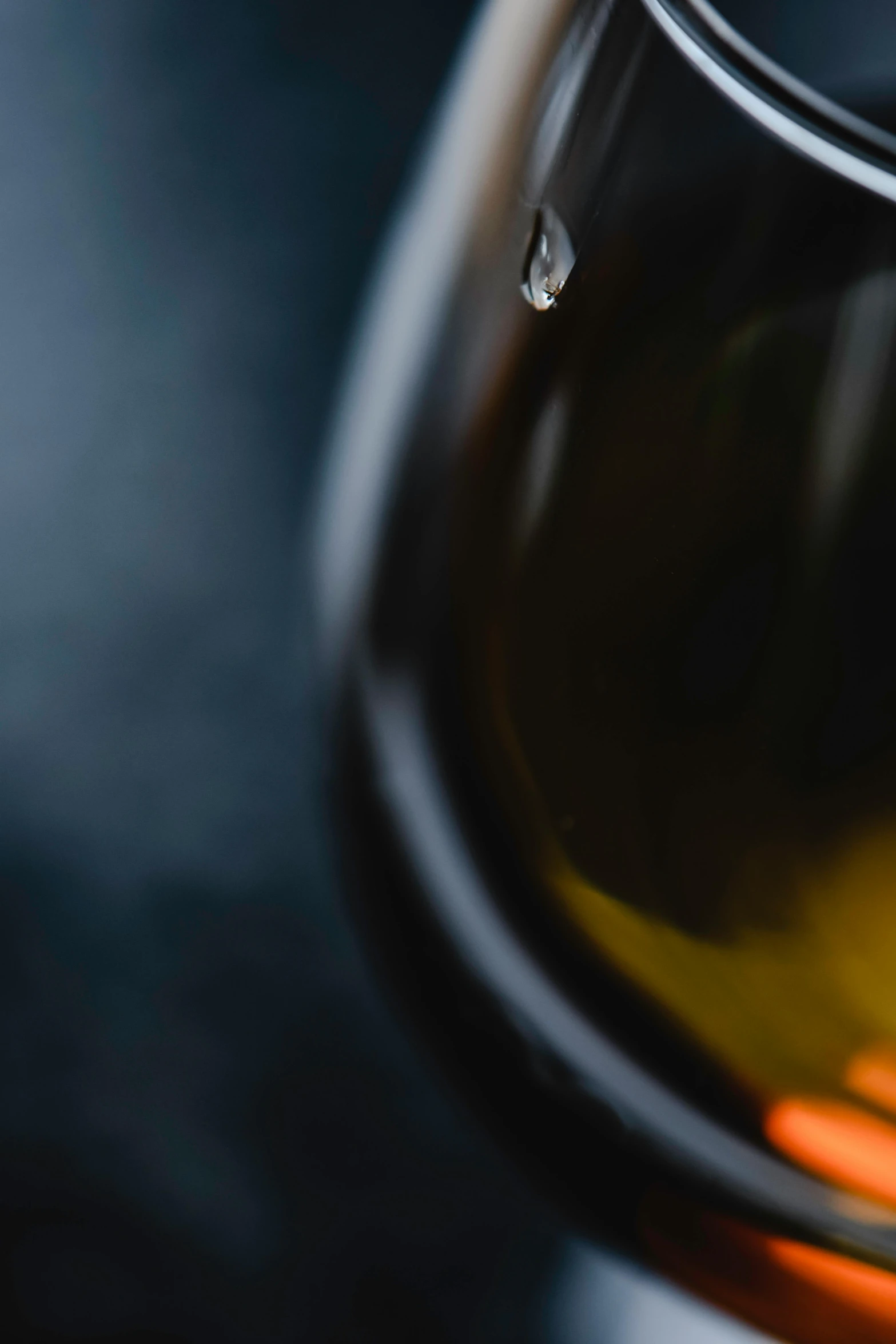 a close up of a glass of wine, a macro photograph, by Adam Marczyński, trending on unsplash, photorealism, weeping tears of black oil, olive oil, maple syrup, dark. no text