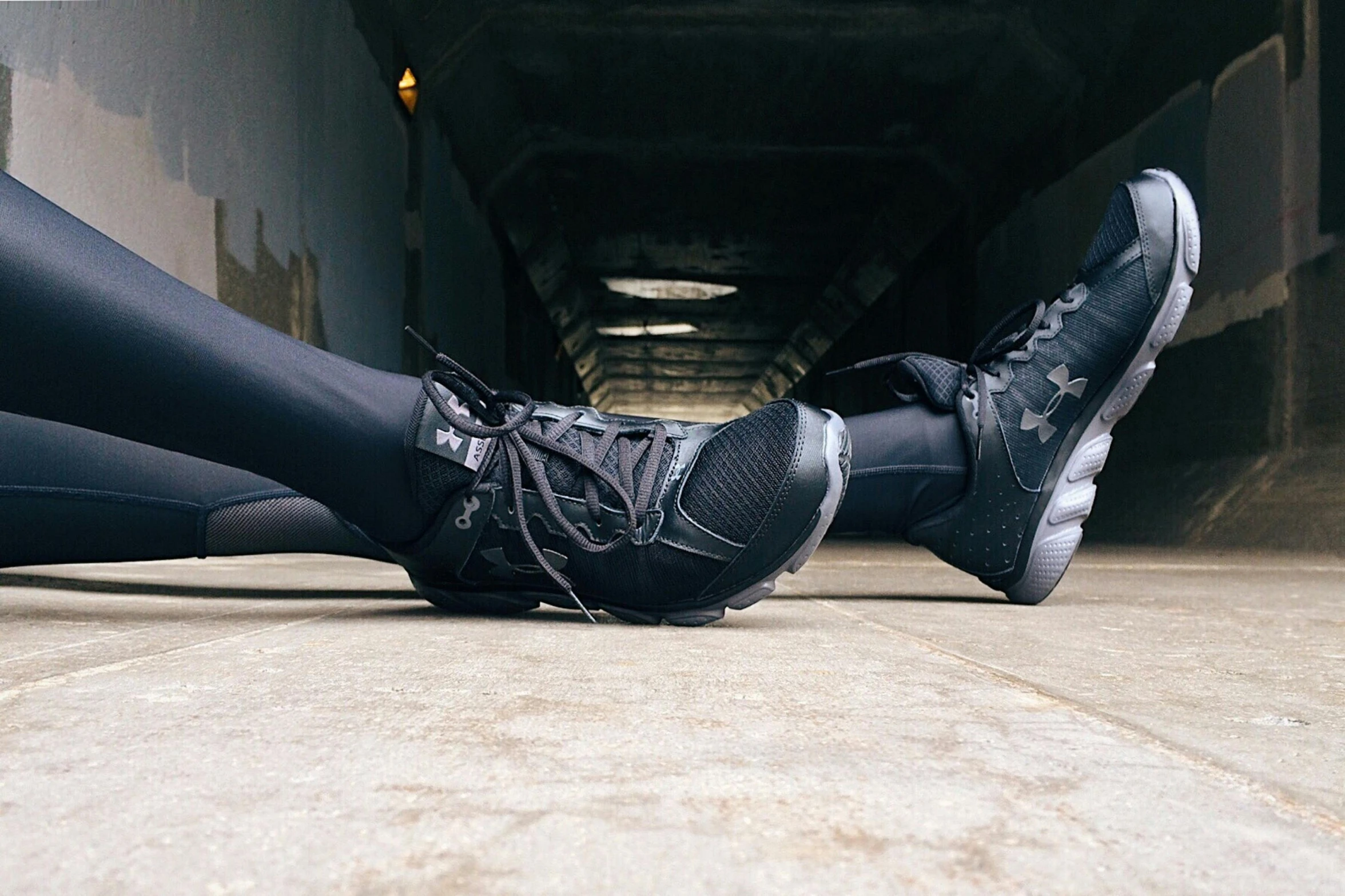 a person that is laying down on the ground, by Nina Hamnett, unsplash, graffiti, black spandex, running shoes, wearing boots, compression