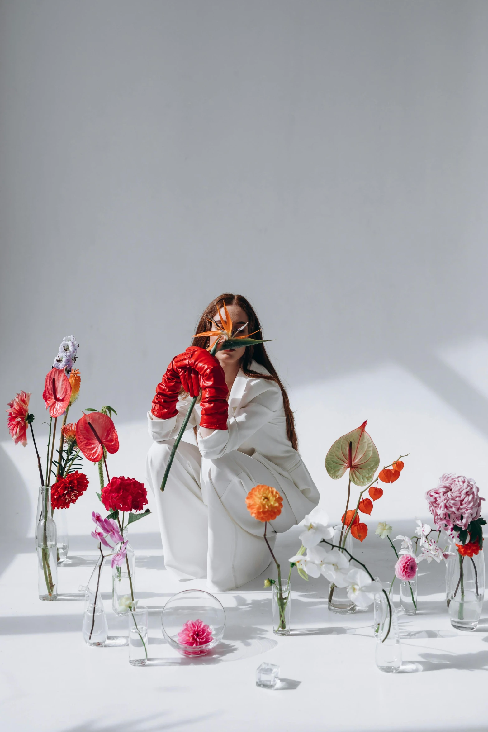 a woman sitting in front of a bunch of flowers, an album cover, trending on pexels, aestheticism, red gloves, in white room, flowers covering eyes, korean artist