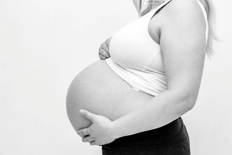 a pregnant woman poses for a black and white photo, pexels, white background!!!!!!!!!!, background image, fetus, motherly