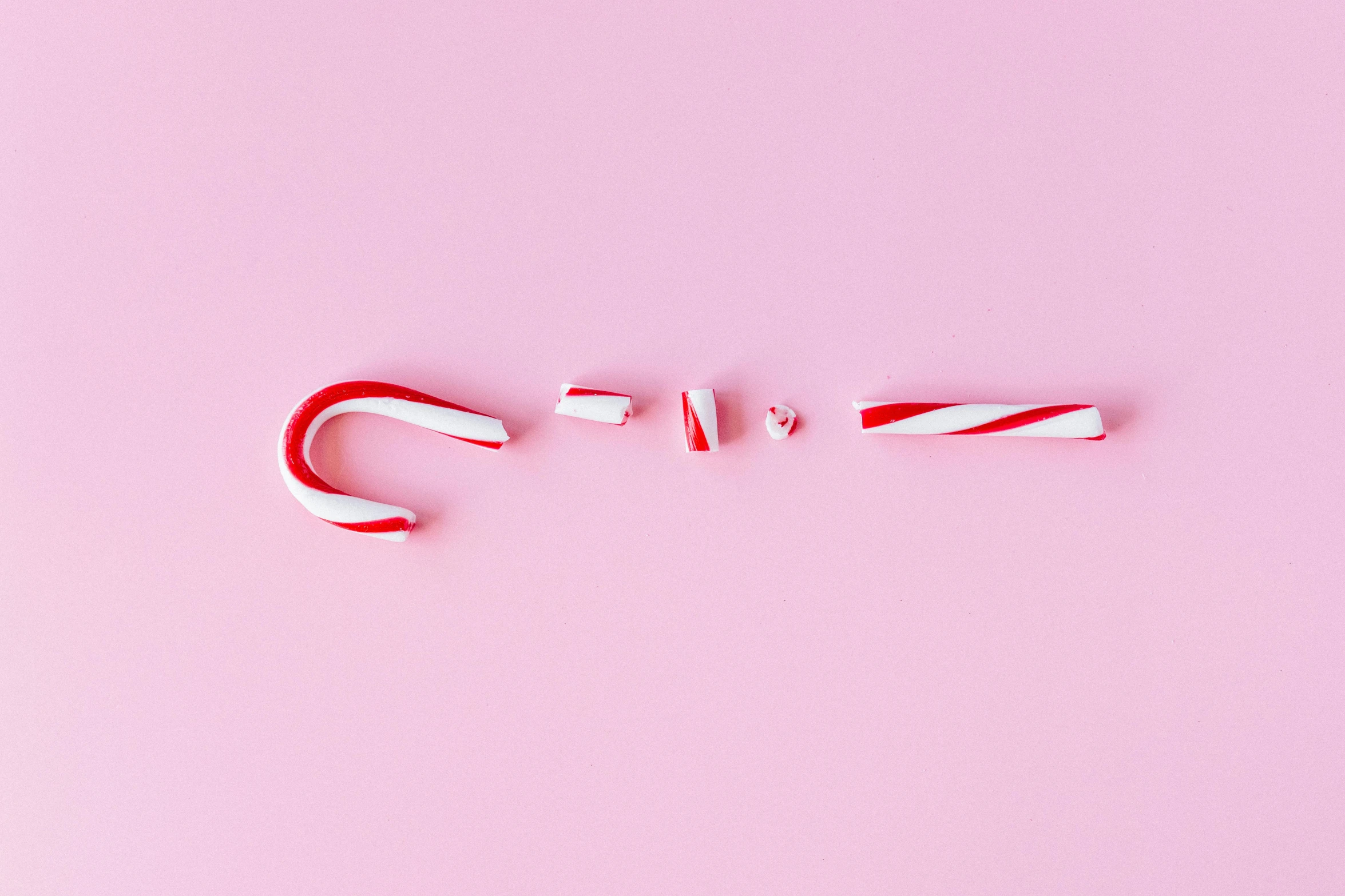 two candy canes on a pink background, inspired by Cerith Wyn Evans, trending on pexels, minimalism, ffffound, the grinch, knolling, letter s