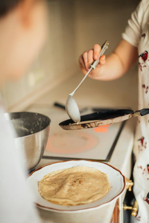 a close up of a person cooking food on a stove, pancake flat head, kids, spoon placed, grey