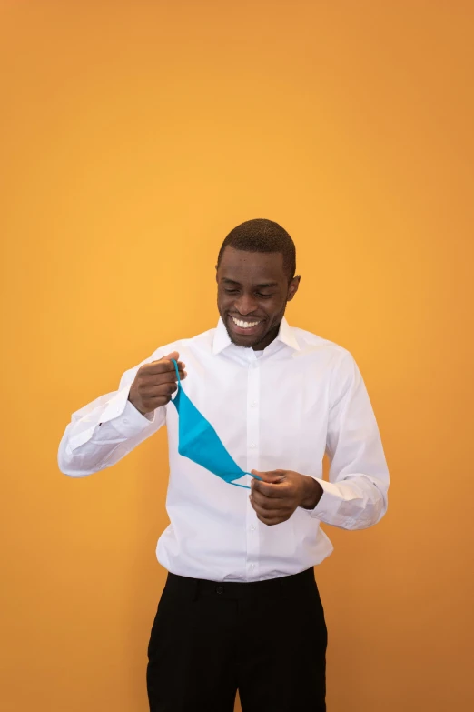 a man in a white shirt and black pants, pexels contest winner, happening, teal paper, ( ( dark skin ) ), cyan and orange, smiling male