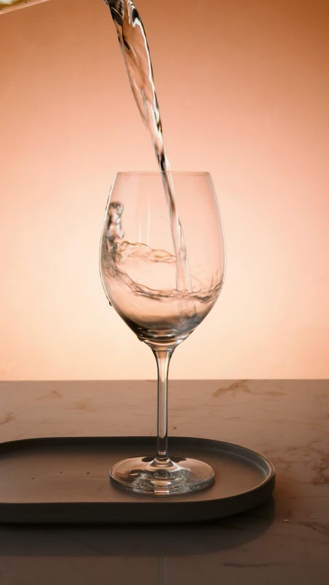 a glass of water being poured into a wine glass, by Joseph Severn, pexels, on a pale background, multiple stories, 834779519