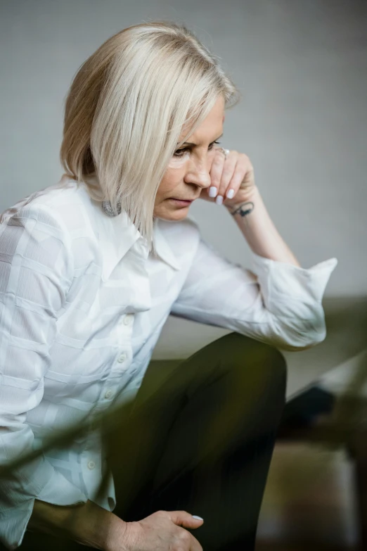 a woman in a white shirt and green pants, trending on unsplash, hyperrealism, relaxed dwarf with white hair, depressed sad expression, sitting down casually, multiple stories