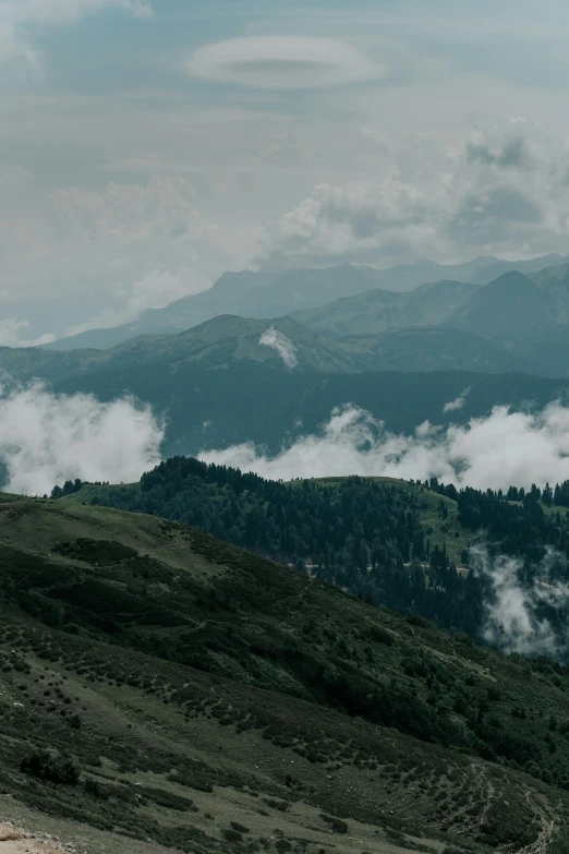 a man riding a horse on top of a lush green hillside, pexels contest winner, renaissance, covered in clouds, 4 k cinematic panoramic view, himalayas, gray skies