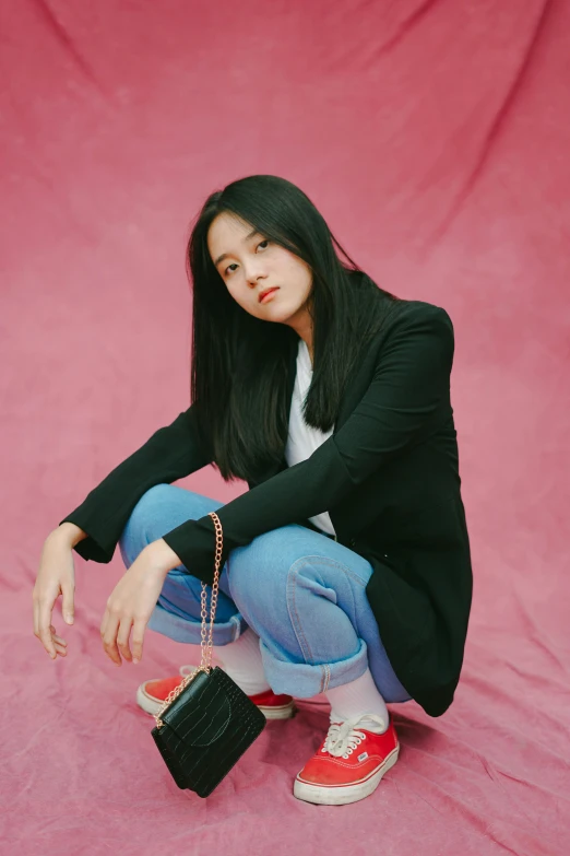 a woman sitting on the ground with a purse, an album cover, inspired by Kim Jeong-hui, pexels contest winner, young cute wan asian face, wearing a black jacket, longque chen, portrait full body