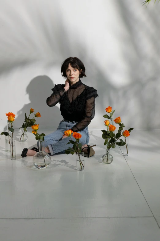 a woman sitting on the floor surrounded by flowers, an album cover, trending on pexels, realism, finn wolfhard, shooting pose, melanchonic rose soft light, standing elegantly