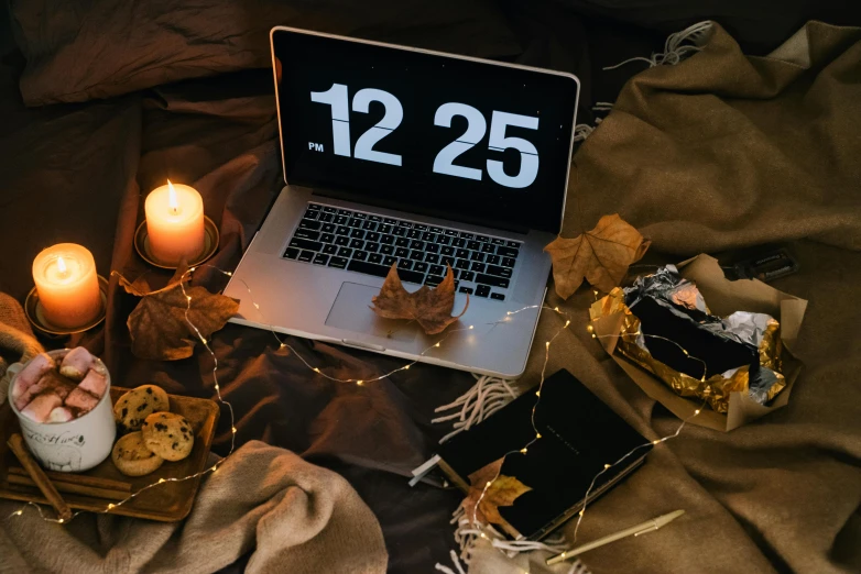 a laptop computer sitting on top of a bed, by Julia Pishtar, trending on pexels, small clocks as leaves, candlelit, countdown, autum