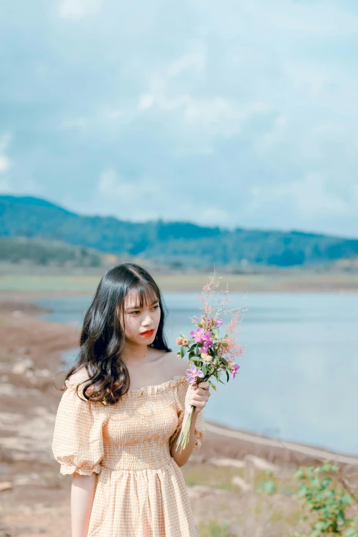 a woman standing next to a lake holding a bouquet of flowers, by Tan Ting-pho, unsplash, romanticism, petite girl, ulzzang, bad looking, female with long black hair
