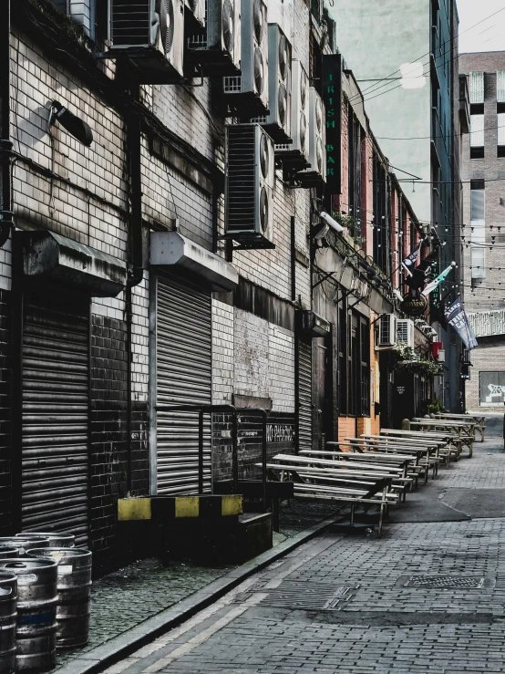 a man riding a motorcycle down a street next to tall buildings, a photo, inspired by Elsa Bleda, pexels contest winner, graffiti, rows of canteen in background, deserted shinjuku junk, today\'s featured photograph 4k, an escape room in a small