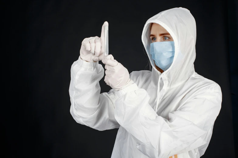 a man in a protective suit is making a gesture, an album cover, by Adam Marczyński, shutterstock, female, holding knife, lab coat, thumbnail