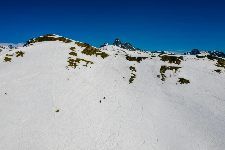 a man riding skis down a snow covered slope, by Peter Churcher, pexels contest winner, les nabis, wide aerial shot, summer day, thumbnail, distant hooded figures