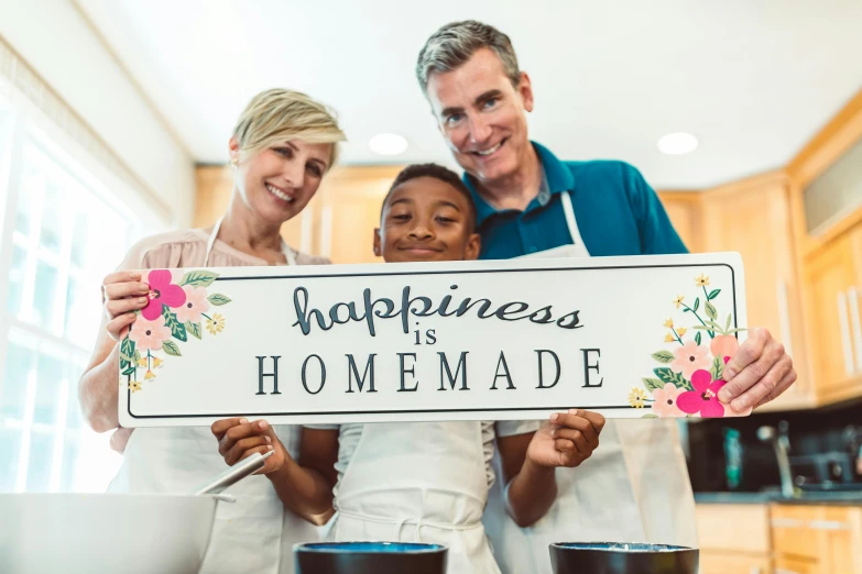 a family holding a sign that says happiness is homemade, pexels contest winner, baking artwork, a person standing in front of a, promo still, flowers around