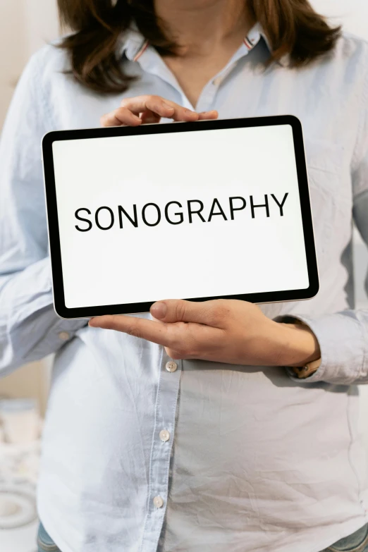 a woman holding a tablet with the word sonography on it, an album cover, inspired by Jens Søndergaard, trending on unsplash, holography, pinhole analogue photo quality, signing autographs, thumbnail, singularity