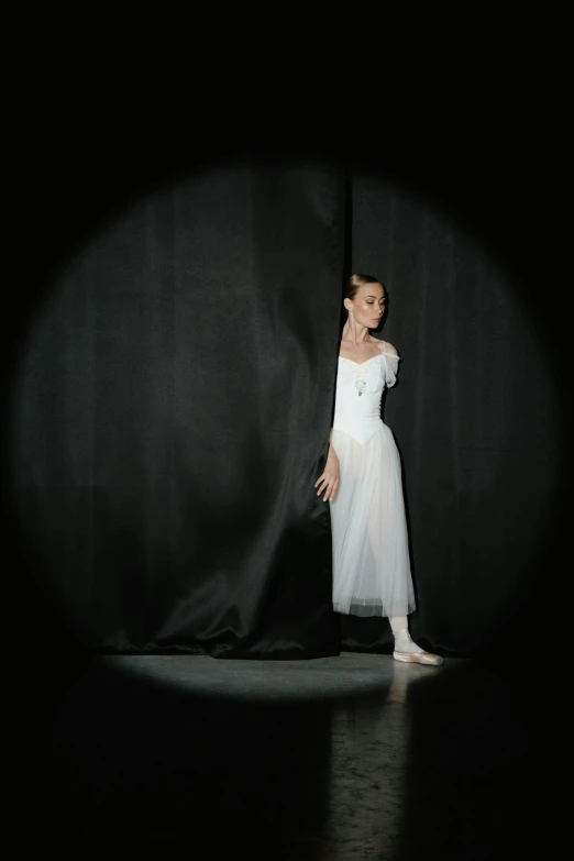 a little girl standing in front of a curtain, by Elizabeth Polunin, arabesque, award - winning photo, white on black, medium format. soft light, media photo