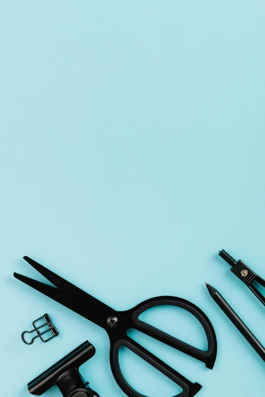 a pair of scissors and other office supplies on a blue background, by Carey Morris, trending on pexels, black and aqua colors, schools, blue-black, uncrop