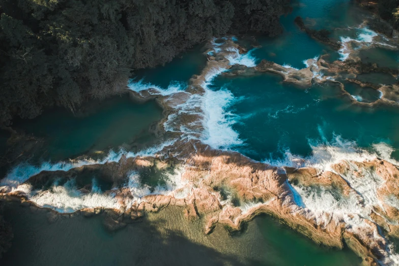 a large body of water next to a forest, by Peter Churcher, pexels contest winner, hurufiyya, circuitry. 8k 3d geology, rapids, air shot, manly