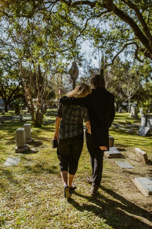 a man and a woman walking through a cemetery, by Meredith Dillman, pexels, jen atkin, sydney hanson, oscar winning, flattened