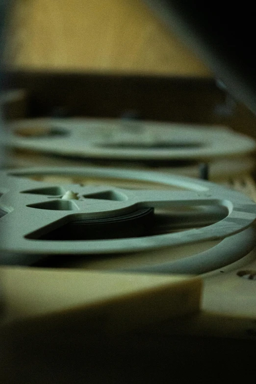 a close up of a film reel on a table, by David Simpson, video art, british pathe archive, turntables, cinema 4d cinematic, panels