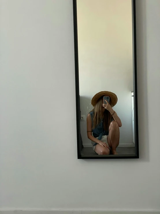 a woman taking a picture of herself in a mirror, by Maggie Hamilton, low quality photo, straw hat, minimalistic!! simple, fullbody photo