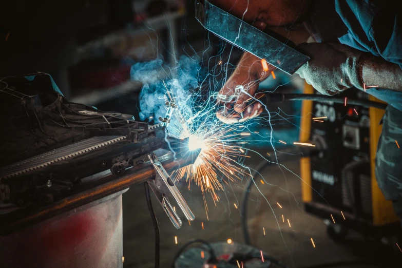 a welder working on a piece of metal, by Lee Loughridge, pexels contest winner, arbeitsrat für kunst, with mechanical arms that fix it, instagram photo, shot on kodak ektar, lachlan bailey