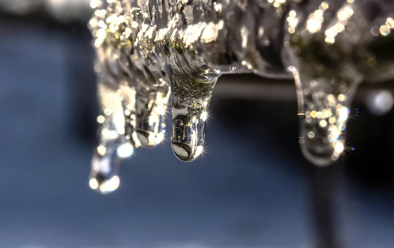 a bunch of icicles hanging off the side of a building, a macro photograph, inspired by Arthur Burdett Frost, unsplash, street lights water refraction, thumbnail, golden hour closeup photo, grey