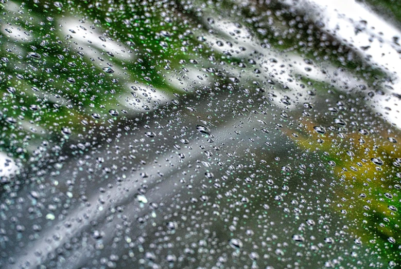 a close up of water droplets on a window, by david rubín, unsplash, windy weather, background image, thumbnail, rainy day in minecraft