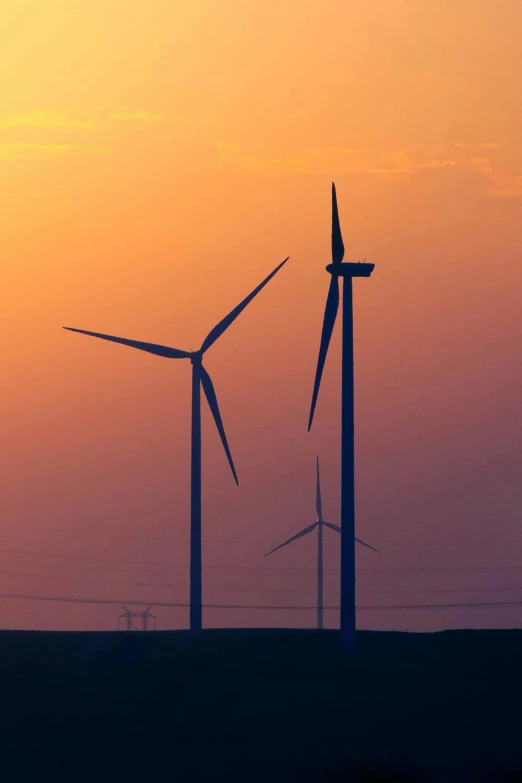 a couple of wind turbines sitting on top of a field, by Joe Stefanelli, slide show, sunset, ap, profile image