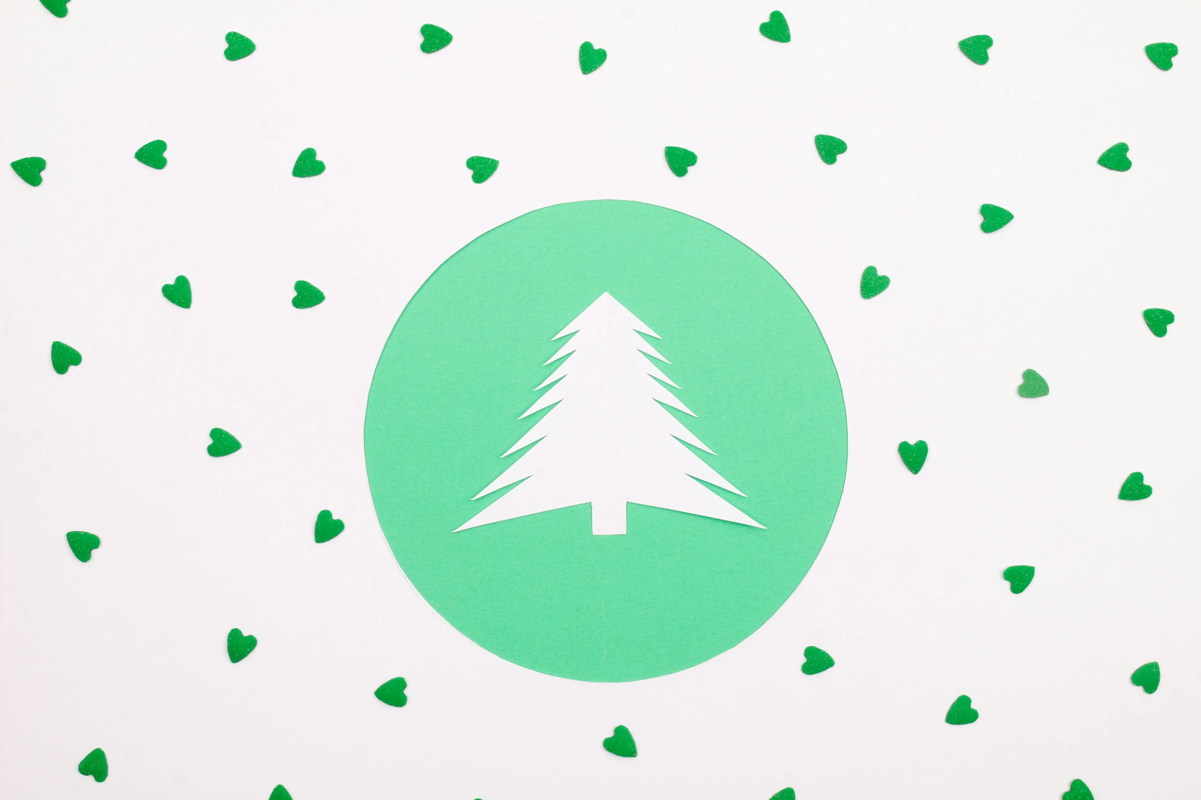 a green christmas tree surrounded by green hearts, a screenprint, trending on pexels, land art, circular logo, as seen from the canopy, paper cut out, minimalist sticker