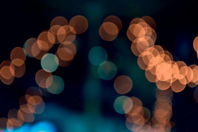 a close up of a cell phone on a table, by Niko Henrichon, unsplash, light and space, dots abstract, orange and cyan lighting, boke, deblurring