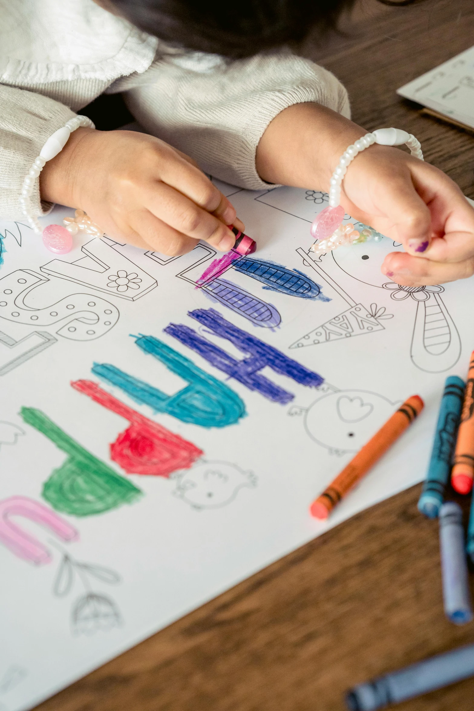 a little girl sitting at a table with crayons, a child's drawing, pexels contest winner, rainbow coloured rockets, islamic, banner, on high-quality paper