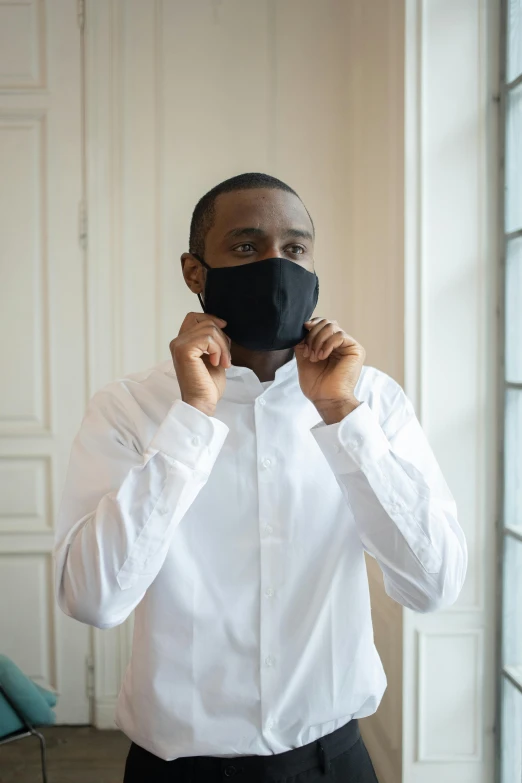 a man in a white shirt and a black mask, inspired by Theo Constanté, wearing a black shirt, lifestyle, black man, lined in cotton