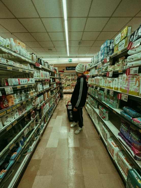 a woman is walking down the aisle of a grocery store, an album cover, inspired by Elsa Bleda, unsplash, hyperrealism, asian man, non-binary, pharmacy, contemplating
