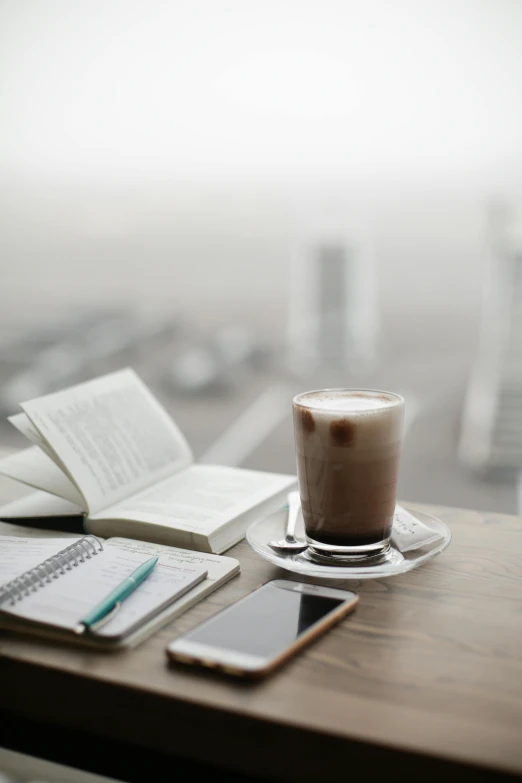 a cup of coffee sitting on top of a wooden table, on vellum, studying, curated collections, android coffee shop