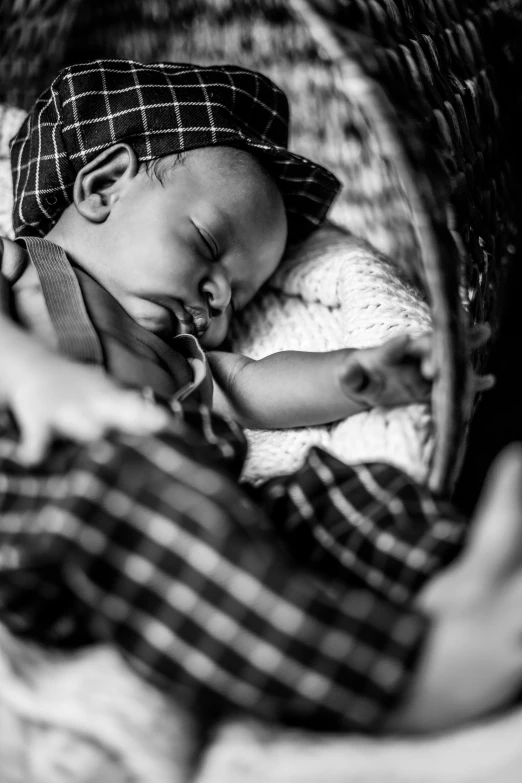 a black and white photo of a baby sleeping in a basket, by Joze Ciuha, uploaded, father with child, lachlan bailey, vignetting