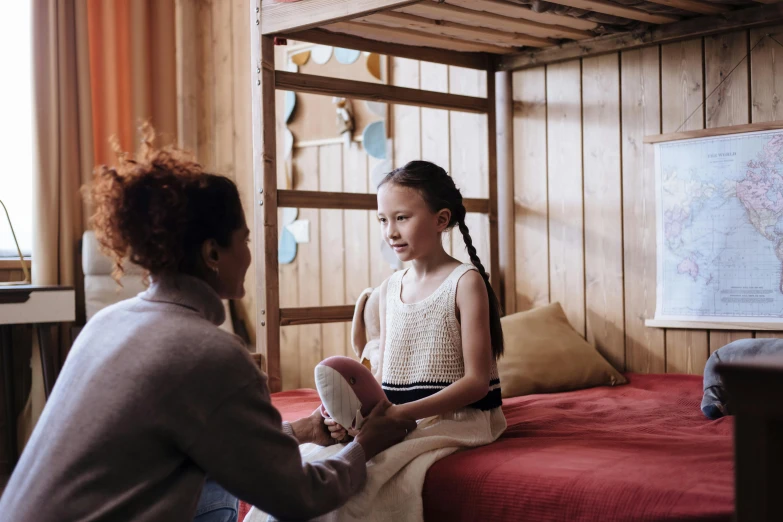 a woman sitting on top of a bed next to a little girl, pexels contest winner, hurufiyya, manuka, calmly conversing 8k, inside of a cabin, young teen