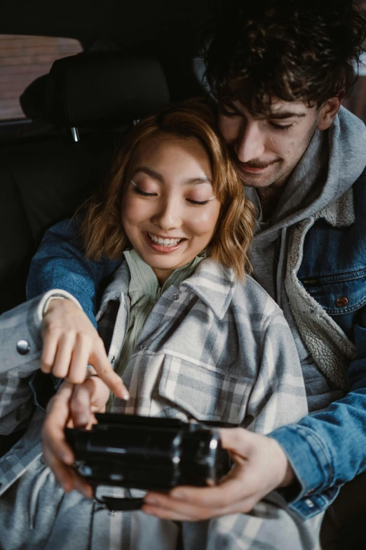 a man and woman sitting in the back of a car, trending on pexels, happening, holding nikon camera, cuddling, switch, japanese