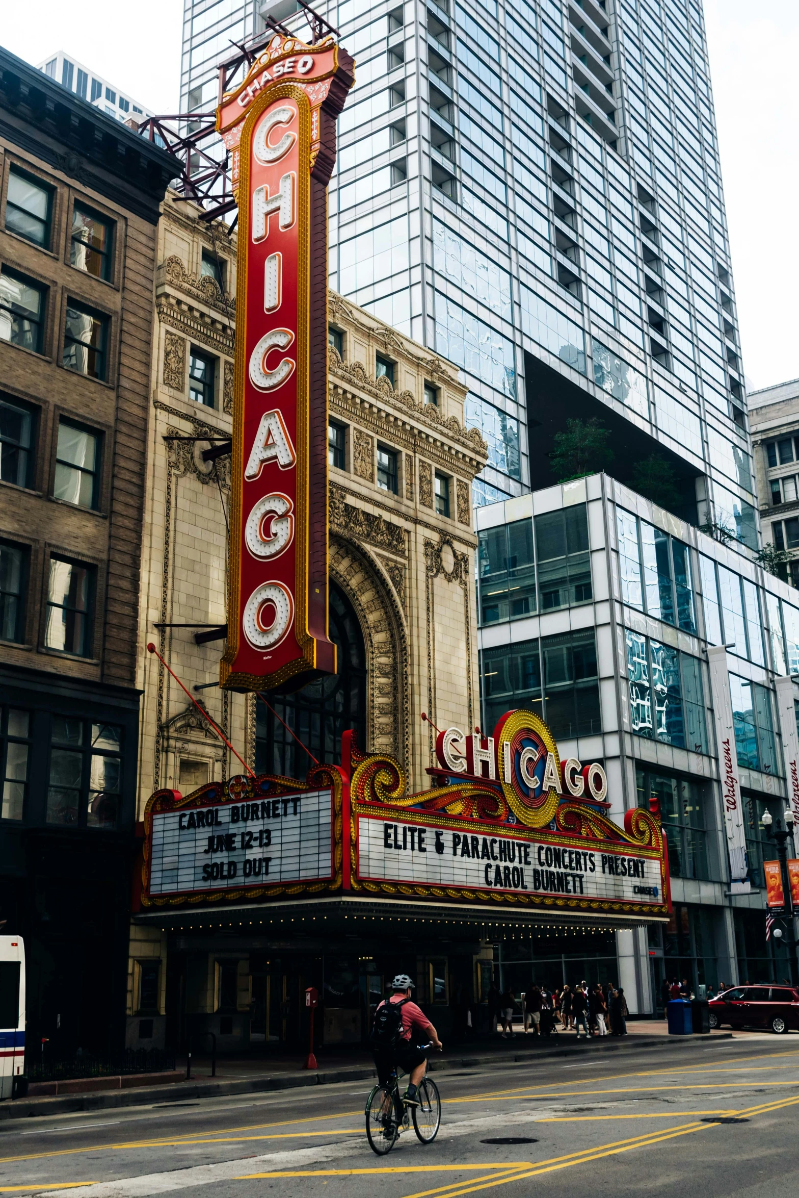 a man riding a bike down a street past tall buildings, by Robbie Trevino, pexels contest winner, art nouveau, photo of a big theaterstage, chicago, sign, chocolate