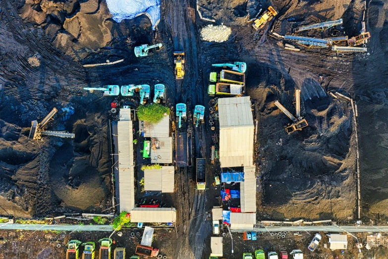 a group of trucks that are sitting in the dirt, a screenshot, by Adam Marczyński, pexels contest winner, buildings covered in black tar, flatlay, bright construction materials, biroremediation plant