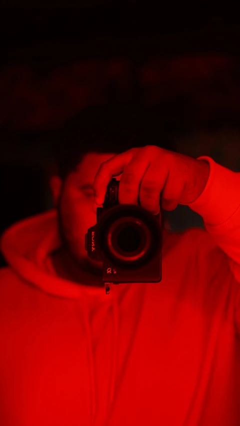 a man taking a picture of himself with a camera, inspired by Elsa Bleda, dramatic red scary lighting, high resolution print :1 red, profile picture, red monochrome