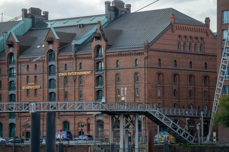 a large red brick building next to a body of water, by Tilo Baumgärtel, pexels contest winner, art nouveau, theatre equipment, all buildings on bridge, warehouses, anato finnstark. front view