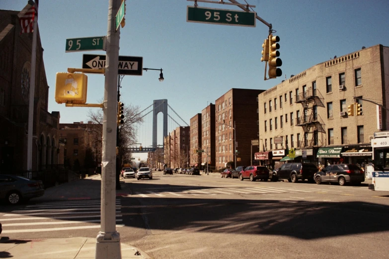 a street filled with lots of traffic next to tall buildings, a picture, by Steve Brodner, unsplash, harlem renaissance, city bay bridge aqueduct, taken in the mid 2000s, ignant, seen from outside