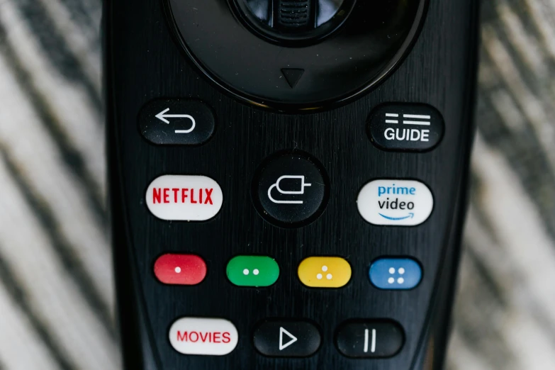 a close up of a remote control on a table, pexels, at netflix, jen atkin, curved, buttons