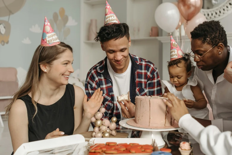 a group of people standing around a table with a cake, profile image, party hats, 1 petapixel image, thumbnail