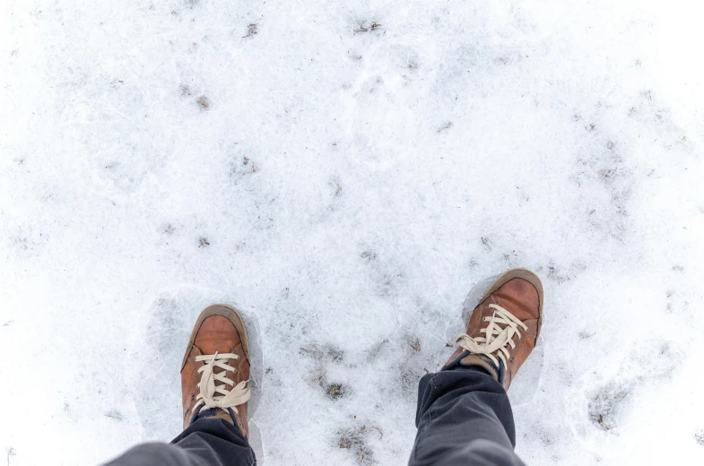 a person standing in the snow wearing brown shoes, trending on pexels, hyperrealism, high above the ground, frozen cold stare, very comfy], february)