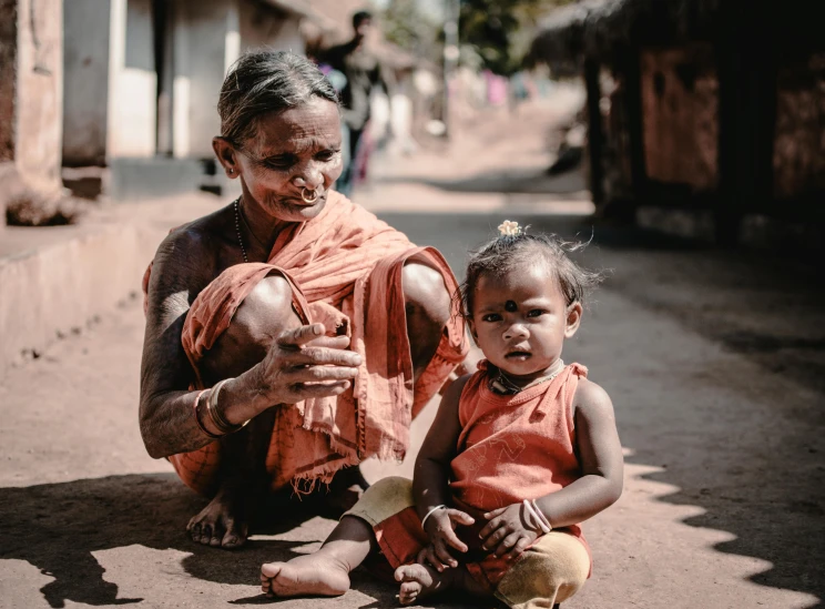 a woman and child sitting on the side of a road, pexels contest winner, symbolism, tribals, emaciated, portrait image, sitting on the floor